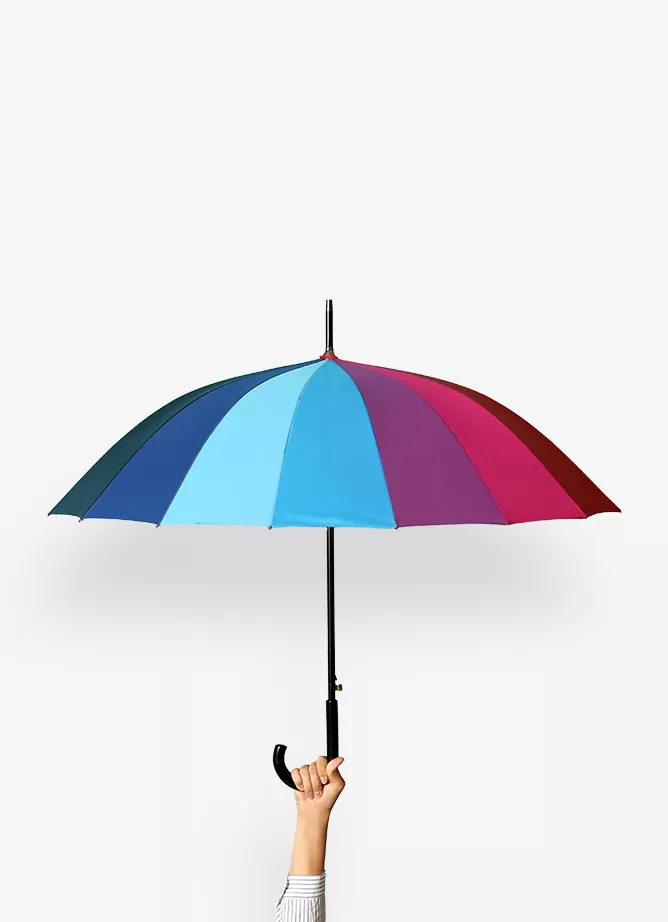 A hand holds up a multi-coloured umbrella